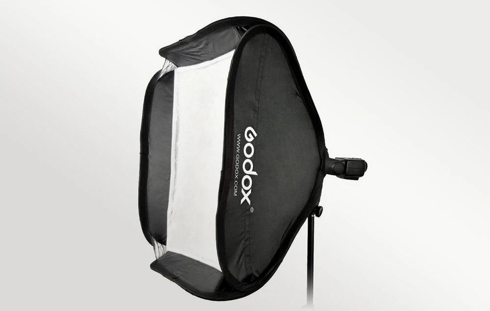 Softbox-ul GODOX SFUV5050 prezentat din profil, cu logo-ul mărcii, montat pe un trepied pe un fundal gri