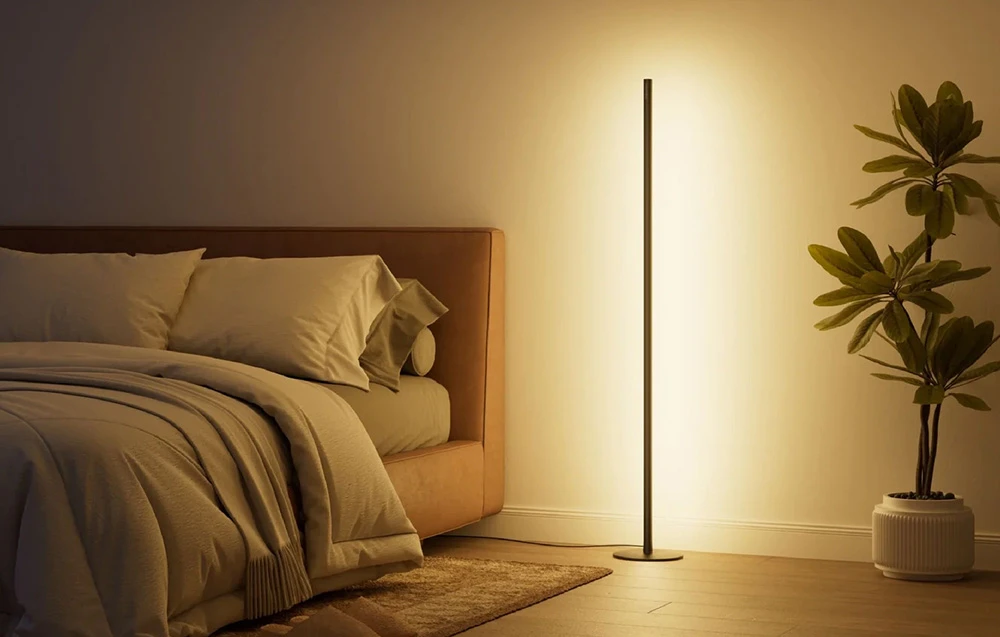 Lampă de podea LED minimalistă în dormitor lângă plantă, lumină galbenă caldă lângă pat