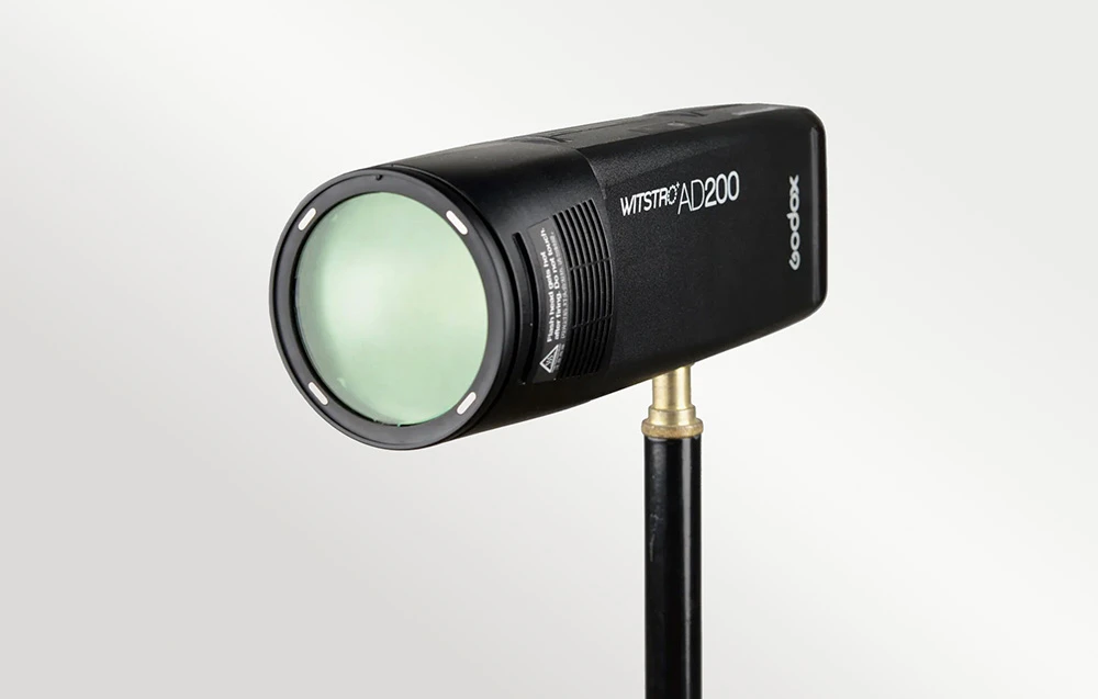 Blițul Godox Witstro AD200 pe un trepied, cu un filtru de efect verde atașat