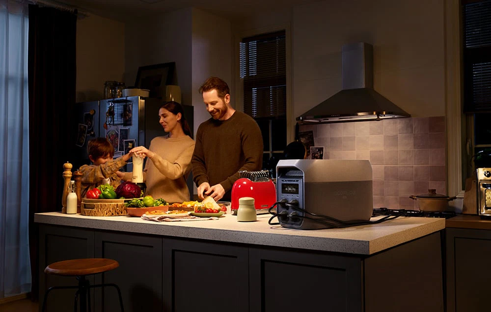 O familie care gătește în bucătărie, cu aparate conectate la stații de alimentare EcoFlow pe blat.