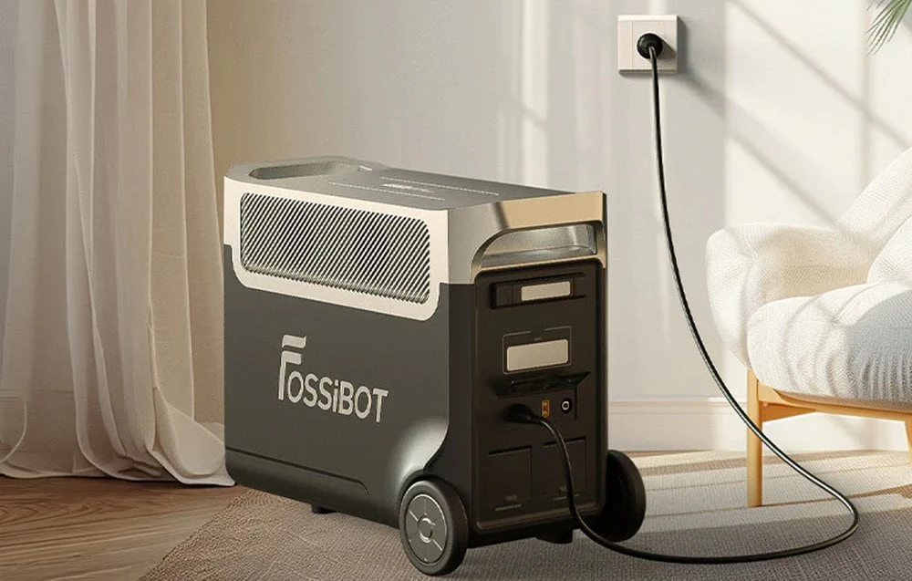 Stația de alimentare portabilă Fossibot, conectată la o priză electrică, se află într-un living modern