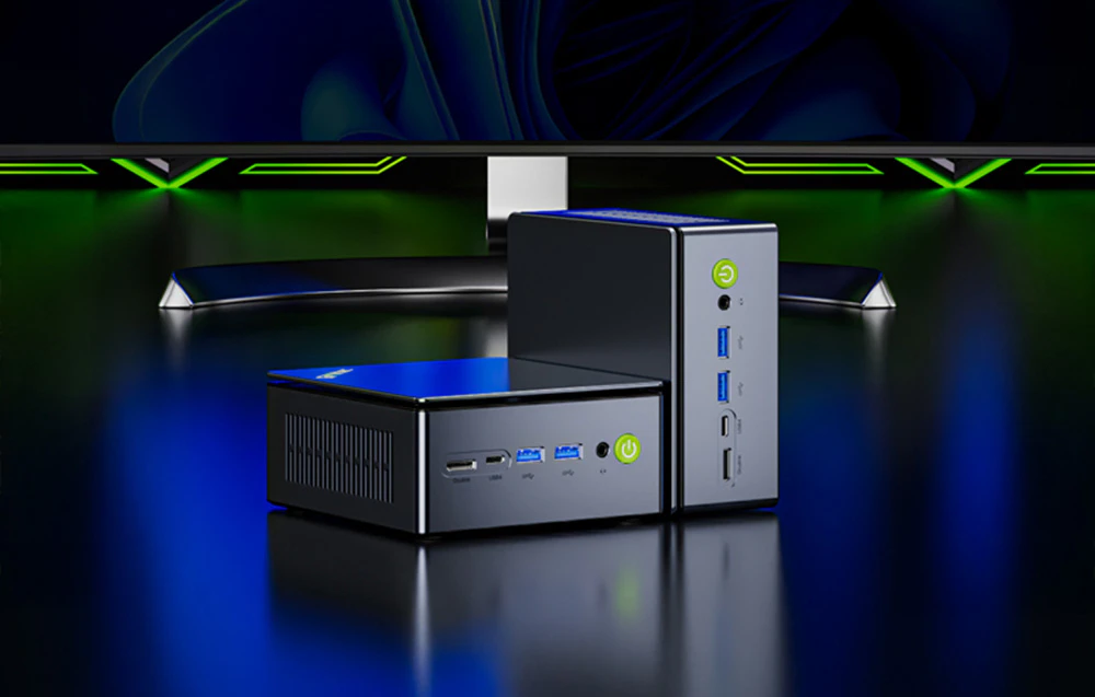 Două mini PC-uri GMKtec prezentate în orientare verticală și orizontală pe fundalul unui monitor.