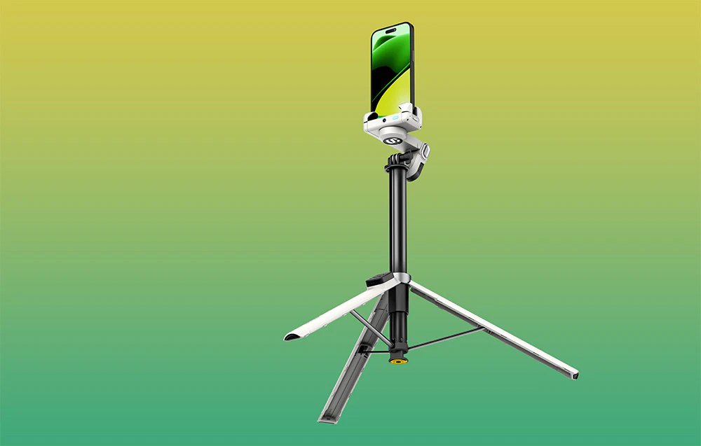 Un gimbal cu un smartphone montat pe un trepied înalt și extensibil, pe un fundal cu gradient galben-verde.