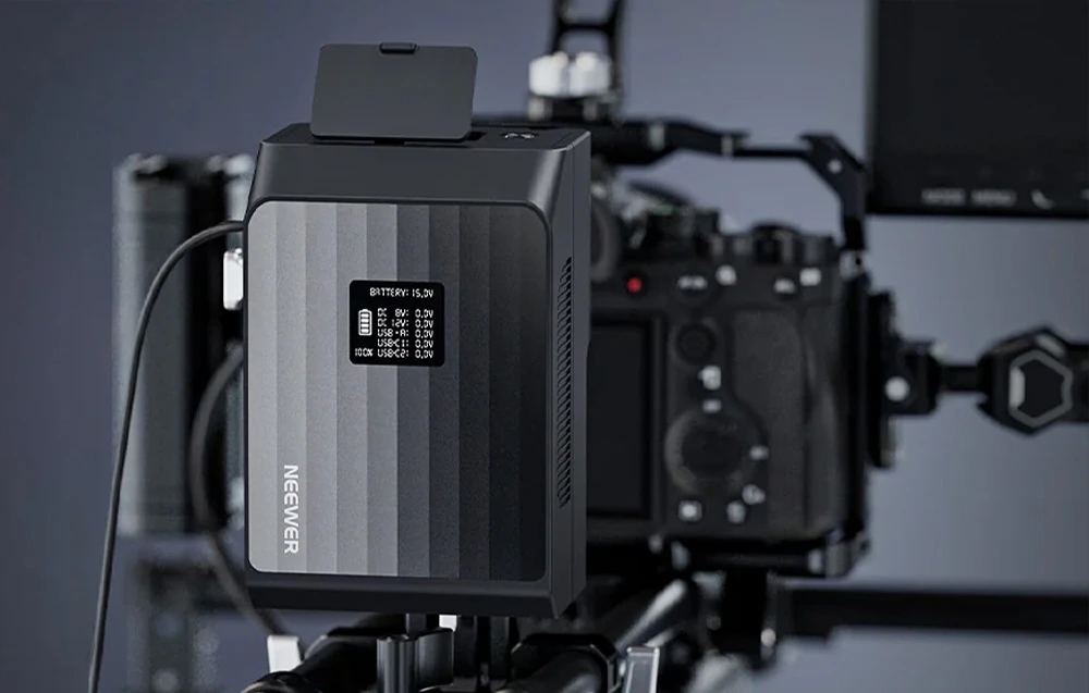 Baterie Neewer V-Mount cu afișaj LCD montată pe un kit profesional de filmare cu o cameră.