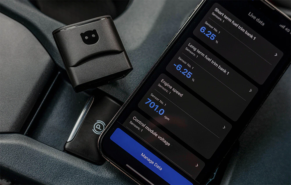 Adaptor Carly și smartphone care afișează datele de diagnosticare ale vehiculului: nivelul combustibilului și tensiunea modulului