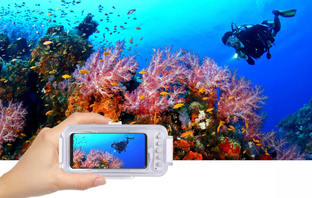 Husă impermeabilă pentru smartphone cu față transparentă și butoane de comandă, produsul fiind prezentat sub apă pe fundalul unui recif de corali.