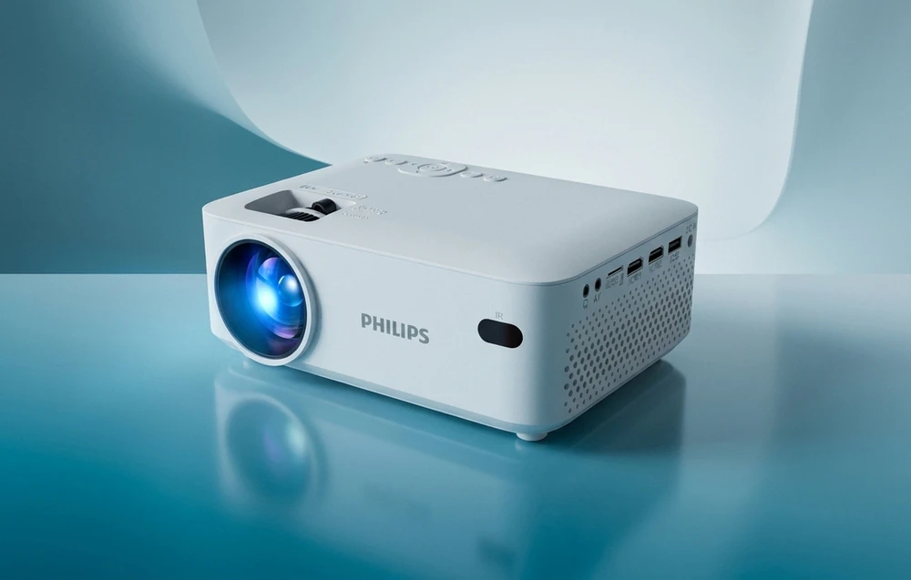 Un proiector PHILIPS alb cu obiectivul deschis pe un fundal albastru uniform
