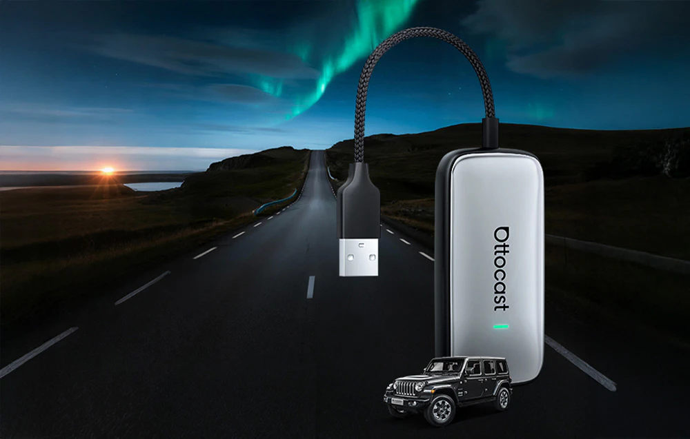 Adaptor Ottocast pe fundalul unei șosele cu aurora boreală, lângă o mașină în miniatură
