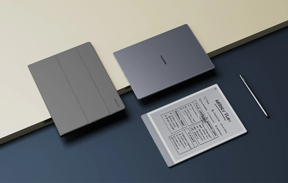 Două dispozitive Huion închise și unul deschis cu un afișaj e-paper care prezintă programul săptămânal, lângă care se află un stylus.