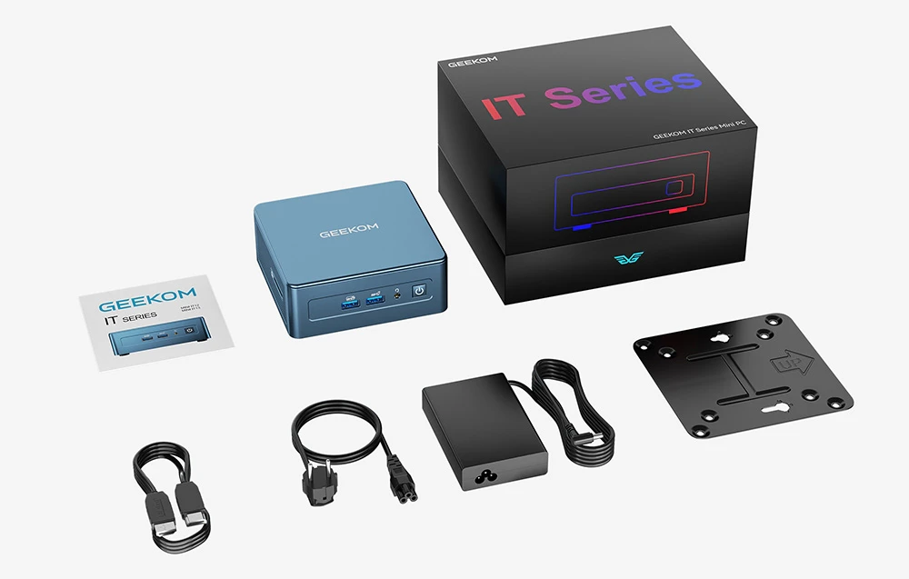 Mini PC GEEKOM albastru lângă o cutie neagră din seria IT, sursă de alimentare, cabluri și manual pe fundal alb