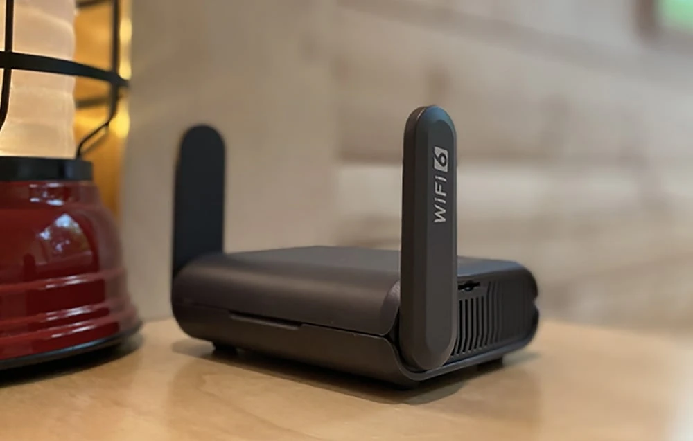 Router negru pe o masă de culoare deschisă
