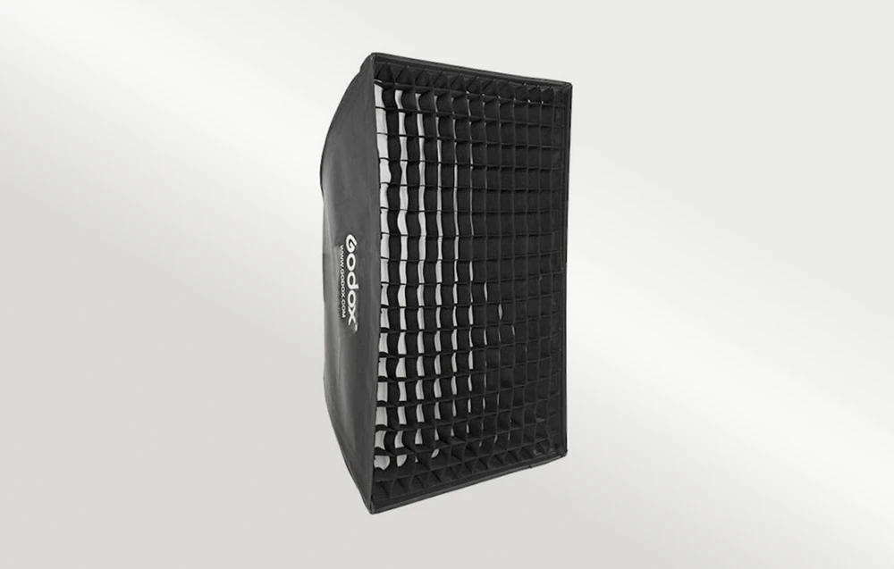 Softbox dreptunghiular negru cu o grilă neagră atașată, prezentat pe un fundal de culoare deschisă.