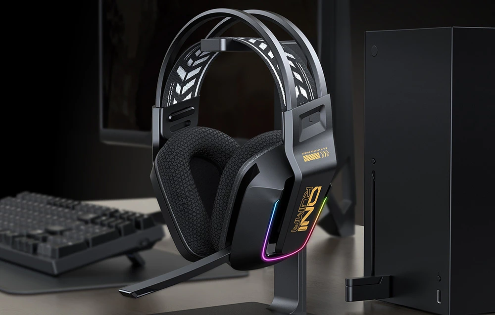 Căști de gaming pe suport lângă tastatură și PC negru pe birou