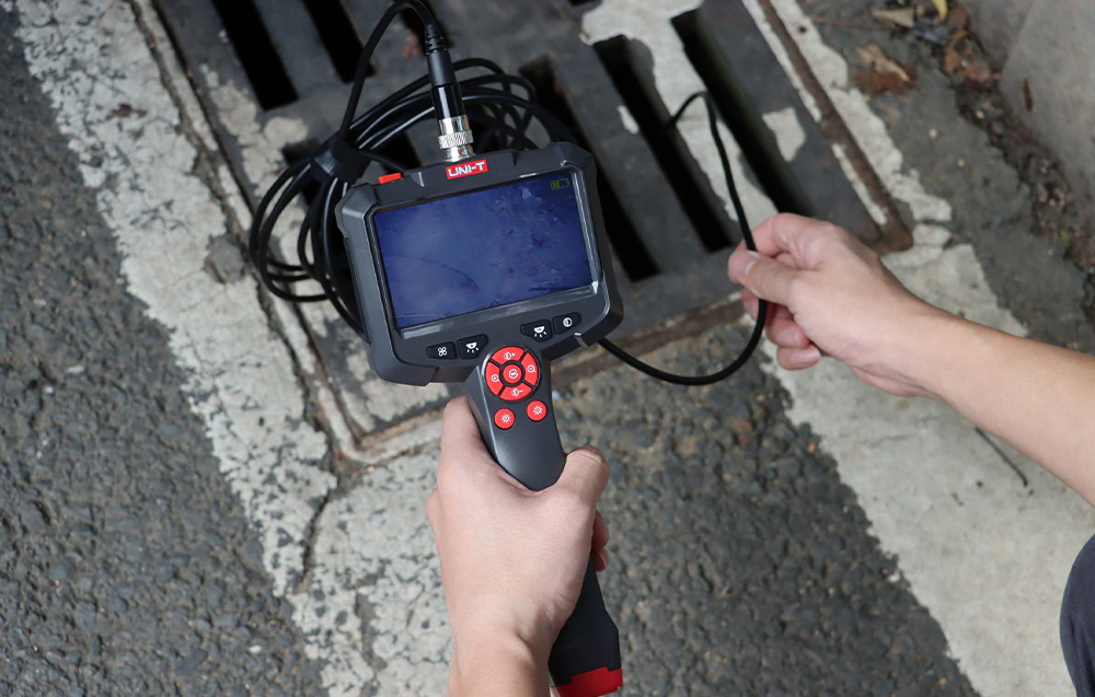 Boroscop video cu ecran și sondă flexibilă utilizat pentru inspectarea interiorului unui puț de acces.