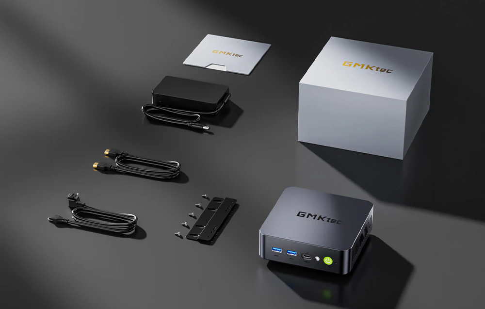 Conținutul kitului, inclusiv mini-computerul GMKtec, sursa de alimentare, cablurile, suportul de montare, șuruburile, manualul și cutia.