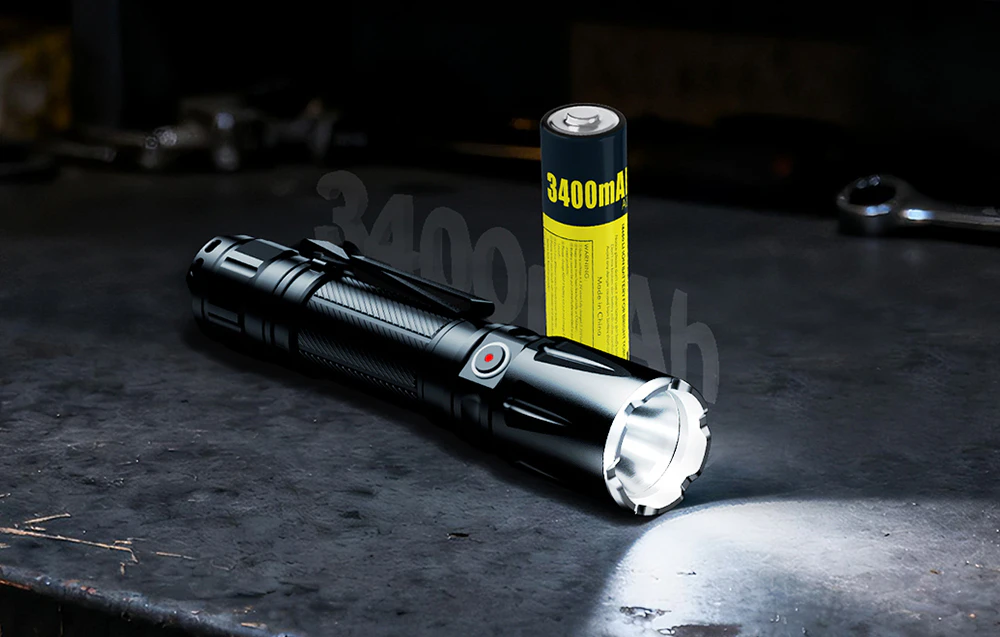Lanternă tactică lângă o baterie de 3400 mAh pe blatul întunecat al unui atelier.