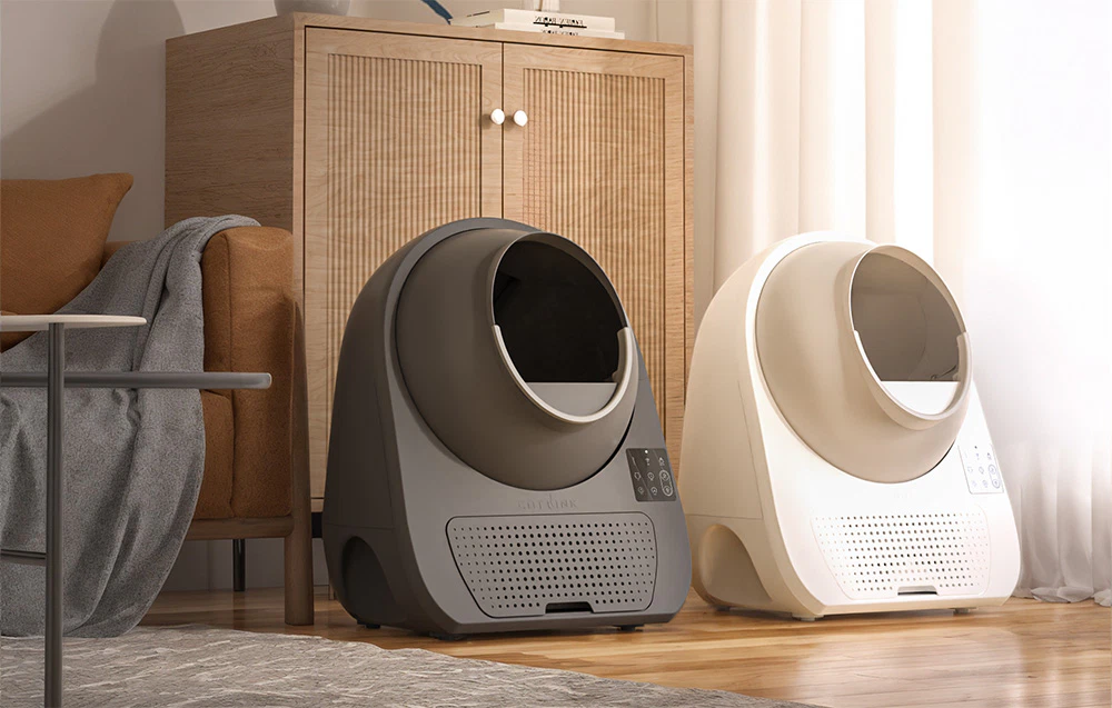 O cutie de nisip automată CatLink, gri și bej deschis, amplasată într-un interior modern lângă un dulap