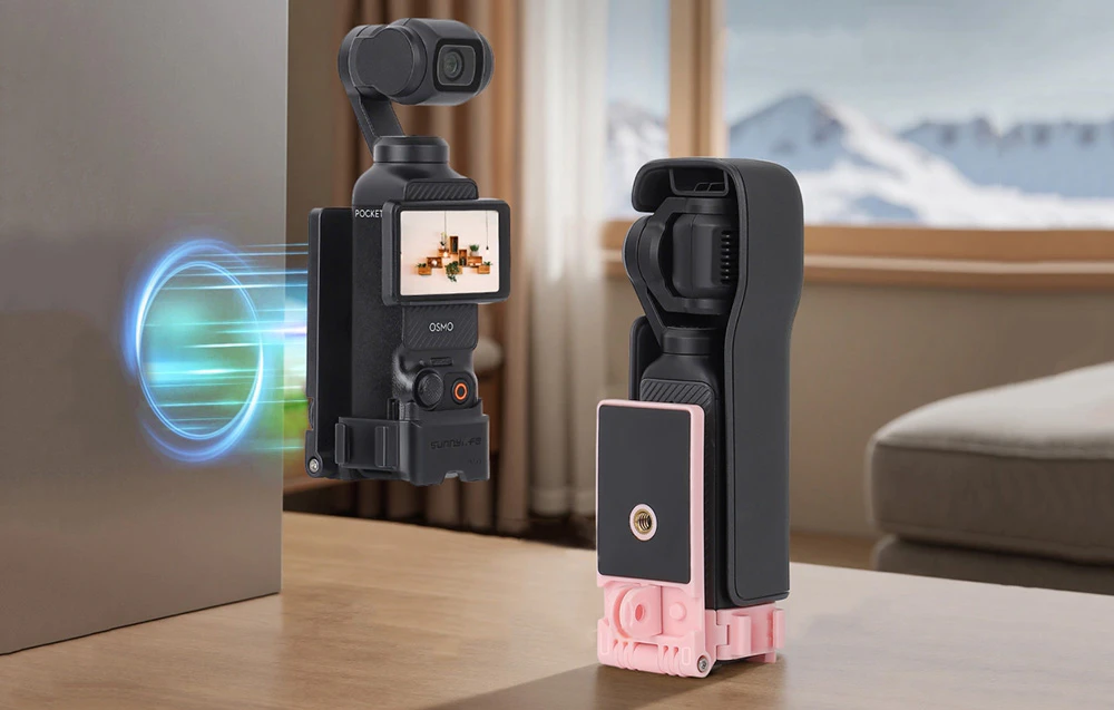 Camera DJI Pocket fixată magnetic pe o suprafață metalică lângă un suport pliat într-o carcasă roz și neagră pe o masă