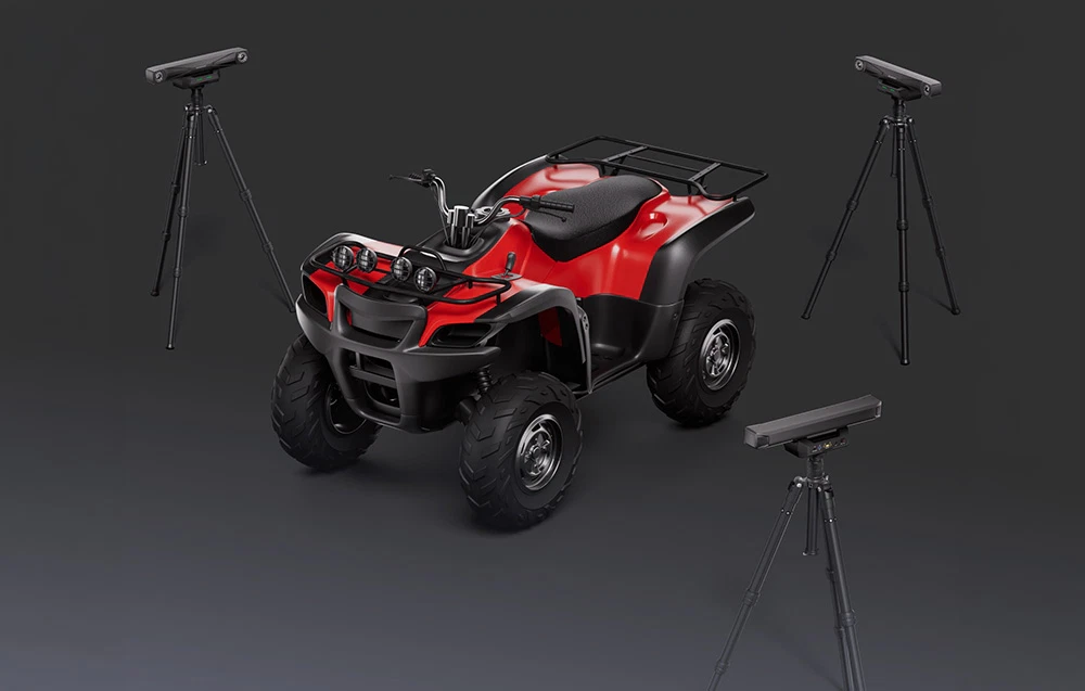 Un quad roșu înconjurat de trei scanere optice 3D montate pe trepiede.