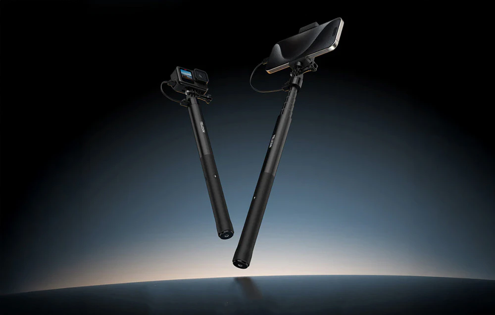 Smartphone și cameră foto atașate la selfie stick pe un fundal întunecat
