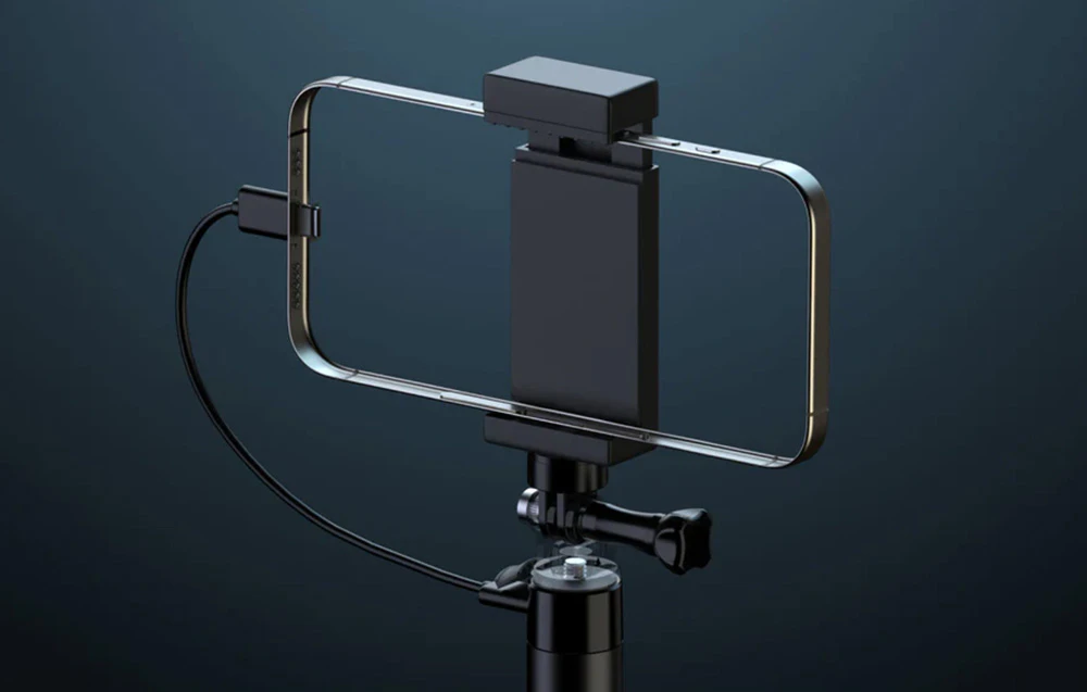 Smartphone atașat la selfie stick și conectat la priză pentru încărcare