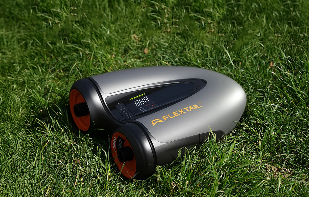 Flextail Evo SUP Pump Pro este așezată pe iarbă, cu afișajul vizibil.