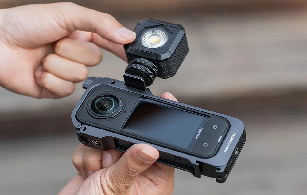 Un bărbat montează iluminarea pe camera Insta360 în carcasă.