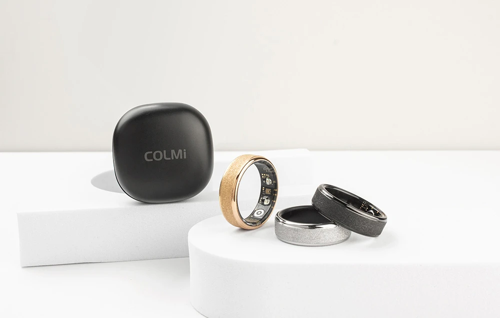 Cele 3 smartwatch-uri Colmi și carcasa de încărcare pe fundal alb.