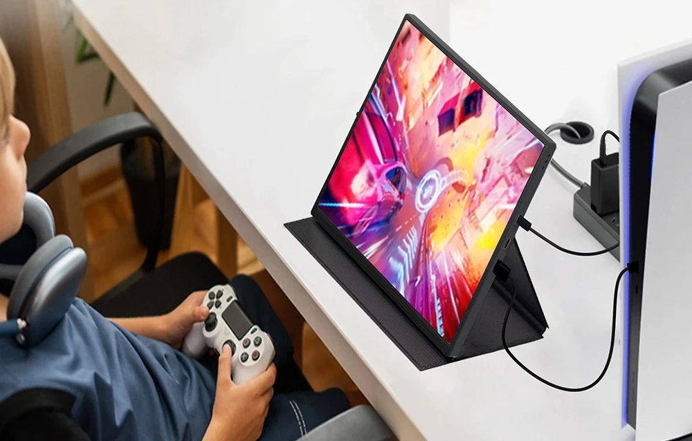 Un copil care se joacă pe o consolă PlayStation conectată la un monitor portabil