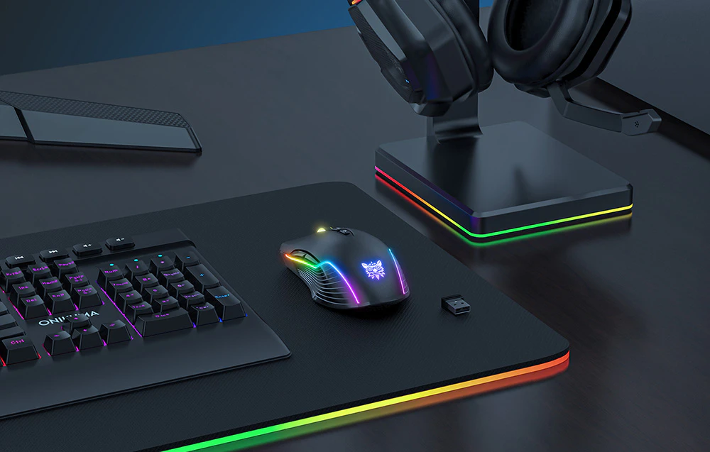 Mouse de gaming fără fir Onikuma CW905 pe birou lângă tastatură.