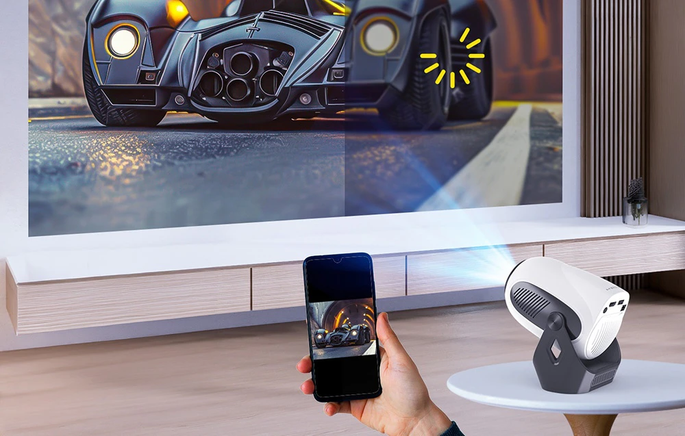Un smartphone conectat la proiectorul Magcubic, care afișează pe ecran o scenă dinamică cu o mașină
