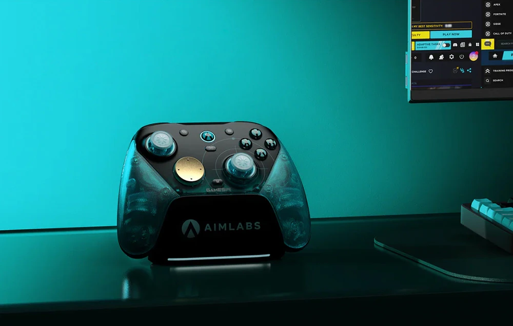 Controler de jocuri pe stația de andocare AIMLABS așezată pe un birou lângă un monitor și o tastatură