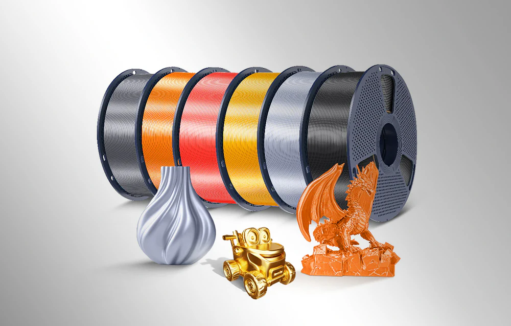 Un rând de bobine colorate cu filament strălucitor și modele imprimate ale unui dragon, unei mașinuțe și unei vaze decorative.