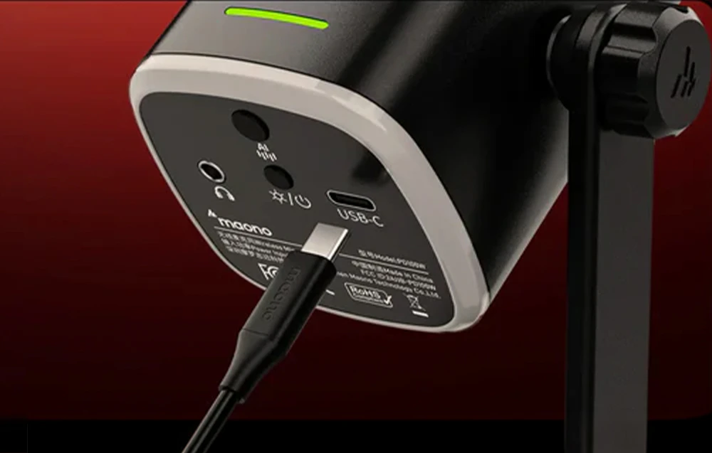 Prim-plan al panoului inferior al microfonului Maono, cu un cablu USB-C conectat și porturi vizibile