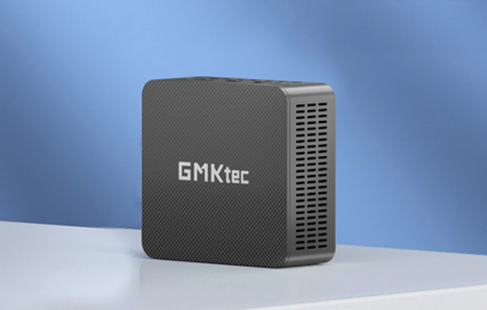 Calculator GMKtec în poziție verticală pe o suprafață luminoasă pe un perete albastru