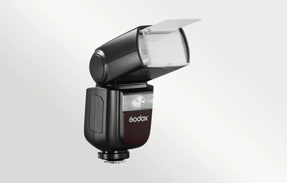 Blițul Godox V860III cu reflectorul alb și difuzorul extins, poziționat în unghi