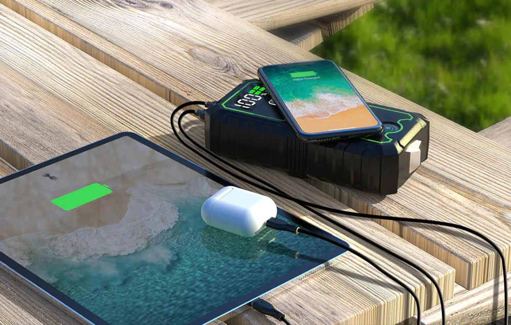 O baterie externă de mare capacitate care încarcă simultan un telefon fără fir și o tabletă prin cablu.