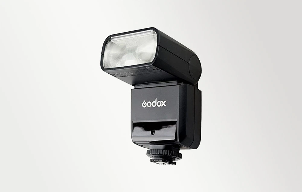 Blițul Godox TT350 negru prezentat din față și din profil, cu capul blițului și logo-ul alb al producătorului
