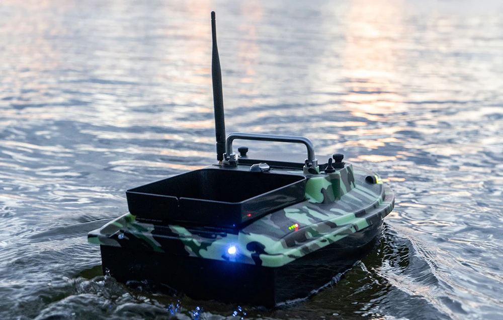 Barca de momeli RC în camuflaj Moro cu iluminare albastră plutind pe lac la amurg
