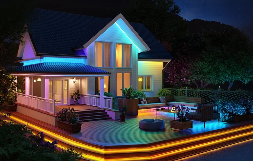 Casă albă cu o terasă mare iluminată cu lumini colorate folosind benzi LED