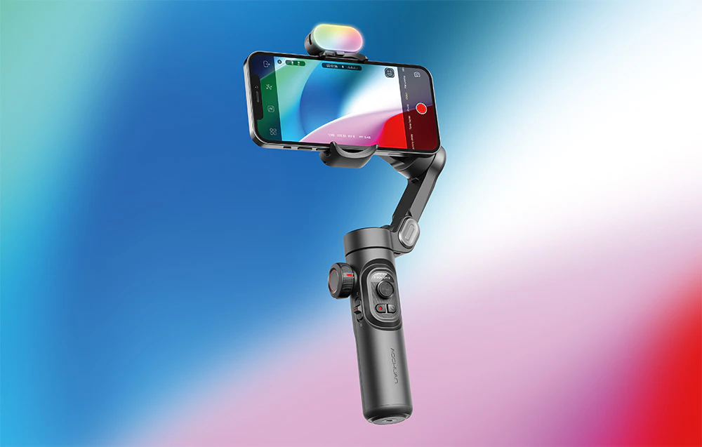 Gimbal cu un smartphone și un modul suplimentar în partea de sus, prezentat pe un fundal cu gradient albastru-roșu.