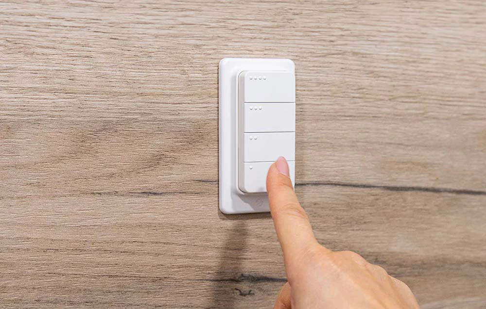 Degetul apăsând unul dintre butoanele de pe telecomanda inteligentă