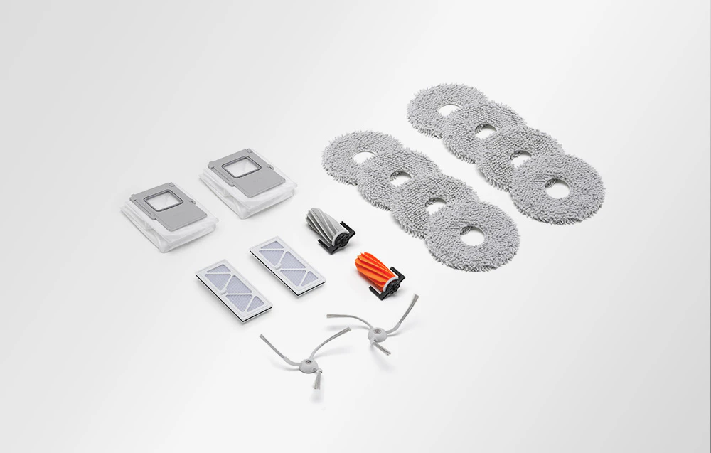 Mop pad-uri, perii de cauciuc, perii laterale, filtre și saci de praf aranjate pe un fundal luminos