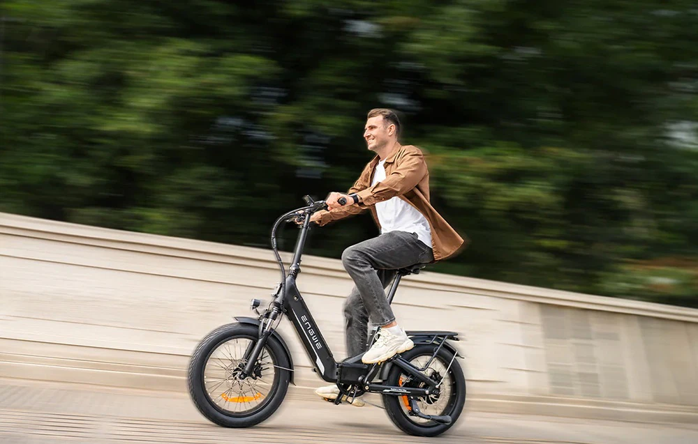 Un bărbat merge pe o bicicletă electrică neagră, cu un fundal estompat care subliniază viteza