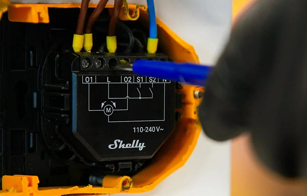 Modul Shelly instalat într-o cutie electrică – firele sunt strânse cu o șurubelniță