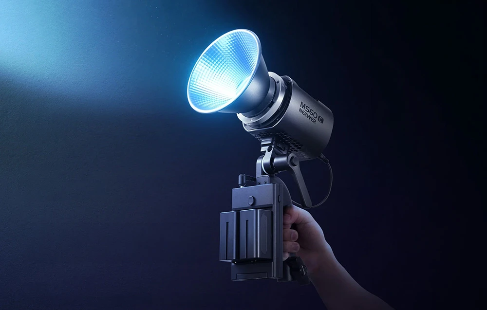 O mână ține o lampă mică și practică, dotată cu o baterie specială care emite o lumină albastră strălucitoare.