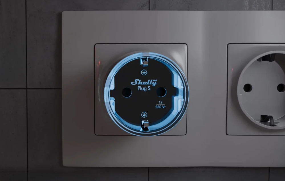 Priză inteligentă Shelly Plug S cu iluminare albastră conectată la o priză de perete