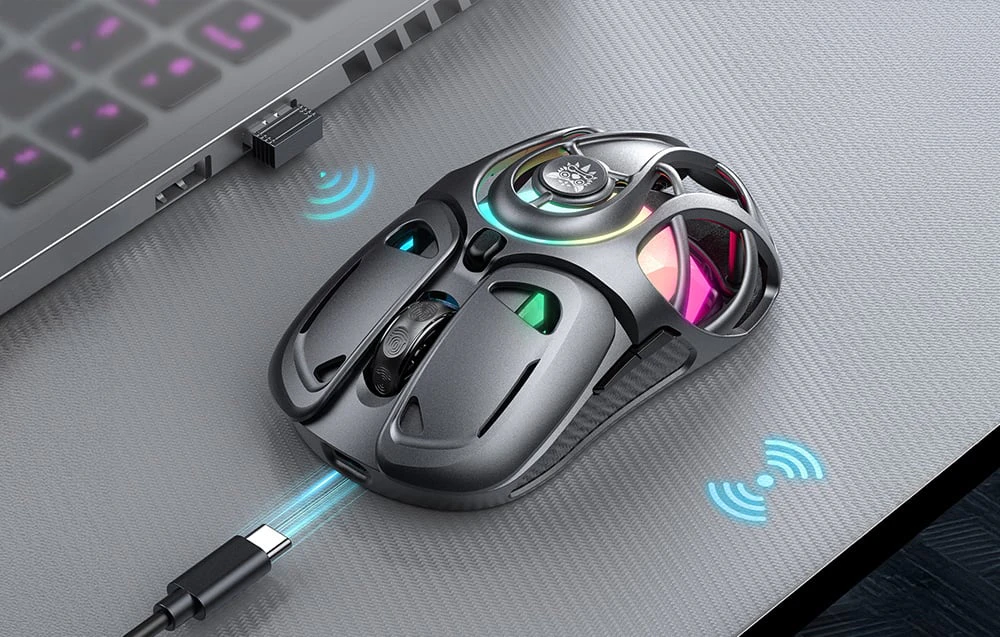 Mouse de gaming negru pe birou lângă laptop cu receptor și cablu