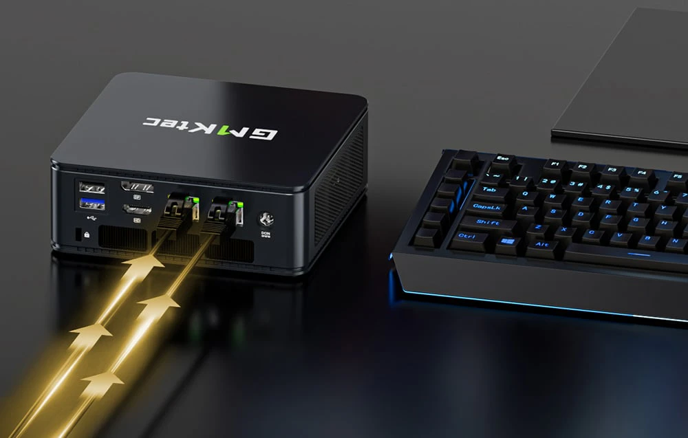 Computer GMKtec pe un birou lângă o tastatură, cu cabluri Ethernet conectate și vizualizarea transferului de date