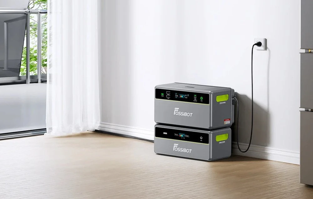 Două baterii Fossibot așezate una peste alta și conectate la o priză electrică de uz casnic
